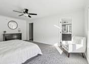 Thumbnail 13 of 26 - A bedroom with a large bed and a white chair.