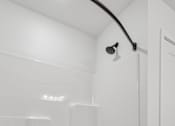 Thumbnail 20 of 26 - A white bathroom with a tub and a shower head.