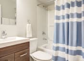 Thumbnail 36 of 46 - a bathroom with a shower curtain and a toilet and sink