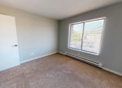Thumbnail 29 of 46 - a bedroom with a large window and carpeted floor