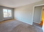 Thumbnail 28 of 46 - an empty living room with a window and carpet