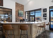Thumbnail 23 of 27 - A modern kitchen with a bar area and chairs.