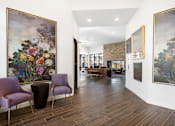 Thumbnail 22 of 27 - A room with a purple chair and a painting of flowers on the wall.