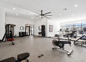 Thumbnail 21 of 27 - A gym with a variety of exercise equipment including a treadmill, rowing machine, and weight machines.