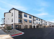Thumbnail 13 of 27 - A row of modern townhouses with garages and driveways.