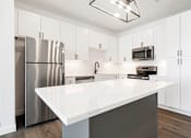Thumbnail 5 of 27 - A kitchen with a white countertop and stainless steel appliances.