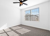 Thumbnail 7 of 27 - A room with a ceiling fan and a window with blinds.