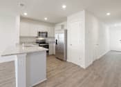 Thumbnail 2 of 19 - A kitchen with a granite countertop and stainless steel appliances.