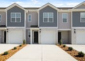 Thumbnail 16 of 19 - A row of modern houses with garages in front.