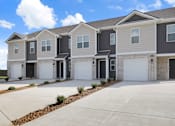 Thumbnail 17 of 19 - A row of modern houses with garages and driveways.