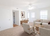 Thumbnail 3 of 33 - A living room with a white couch, a coffee table, and a ceiling fan.