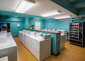 Thumbnail 30 of 41 - A laundromat with washers and dryers is shown.