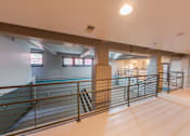 Thumbnail 32 of 41 - A spacious indoor area with a metal railing and a pool in the background.