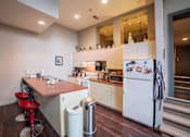 Thumbnail 7 of 41 - A kitchen with white appliances and a red bar stool.