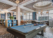 Thumbnail 27 of 32 - A pool table is in the middle of a room with a view of the city.