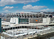 Thumbnail 31 of 32 - A large stadium with a parking lot in front of it.