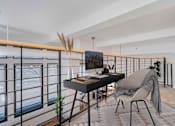 Thumbnail 2 of 32 - A modern living room with a balcony and a chair.
