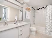 Thumbnail 5 of 32 - A white bathroom with a toilet, sink, and shower.