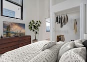 Thumbnail 4 of 32 - A bedroom with a large bed and a painting on the wall.