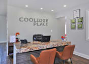 Thumbnail 4 of 28 - A reception area with a marble counter and chairs.