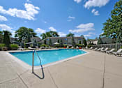 Thumbnail 25 of 28 - A swimming pool surrounded by chairs and trees.