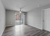 Thumbnail 6 of 23 - A room with a ceiling fan and sliding glass doors.