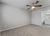 Thumbnail 10 of 23 - A room with a ceiling fan and carpeted floor.
