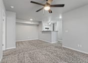 Thumbnail 18 of 23 - A room with a ceiling fan and carpeted floor.
