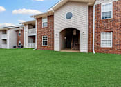 Thumbnail 22 of 23 - A large house with a green lawn in front.
