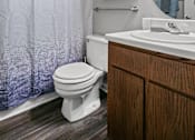 Thumbnail 16 of 33 - A white toilet sits next to a wooden cabinet in a bathroom.