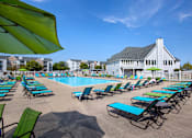 Thumbnail 17 of 29 - A pool surrounded by lawn chairs and umbrellas.