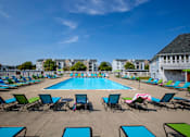 Thumbnail 18 of 29 - A large swimming pool surrounded by lawn chairs.
