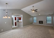Thumbnail 2 of 29 - A spacious living room with a fireplace and a ceiling fan.