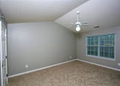 Thumbnail 4 of 29 - A room with a ceiling fan and a window with blinds.