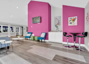 Thumbnail 11 of 29 - A brightly colored room with a pink wall and a white table.