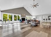 Thumbnail 10 of 29 - A spacious living room with a grey sofa and a wooden floor.