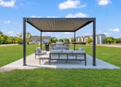 Thumbnail 19 of 29 - A white couch is on a patio under a canopy.