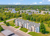 Thumbnail 25 of 29 - A large building complex with a parking lot in front.