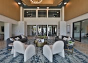 Thumbnail 13 of 38 - A modern living room with a large rug and white chairs.