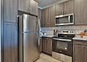 Thumbnail 3 of 38 - A kitchen with a stainless steel refrigerator, microwave, and oven.