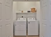 Thumbnail 9 of 38 - A white laundry room with a washer and dryer.