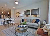 Thumbnail 4 of 38 - A modern living room with a glass coffee table and a grey sofa.