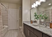 Thumbnail 7 of 38 - A bathroom with a white door and striped shower curtain.