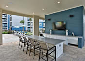 Thumbnail 24 of 32 - A patio with a bar and chairs.