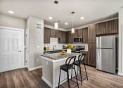 Thumbnail 1 of 32 - a kitchen with a island and a stainless steel refrigerator