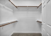 Thumbnail 5 of 32 - a walk in closet with white walls and rails and a white door