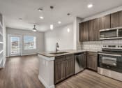 Thumbnail 8 of 32 - an empty kitchen with wooden cabinets and stainless steel appliances