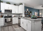 Thumbnail 5 of 30 - a kitchen with white cabinets and stainless steel appliances