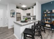 Thumbnail 8 of 30 - a kitchen with a counter with chairs and a