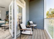 Thumbnail 12 of 30 - a porch with two chairs and a sliding glass door